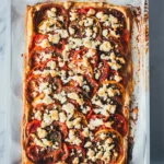 Als Topshot fotografierte, frisch gebackene Tomatenquiche auf dem Blech.