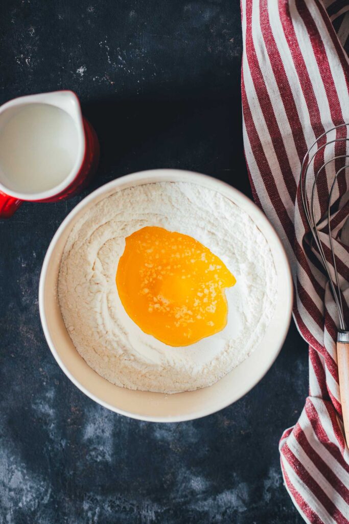 Teig für Pancakes in der Zubereitung – Zutaten wie Mehl, Ei und zerlassene Butter in einer Rührschüssel | moeyskitchen.com