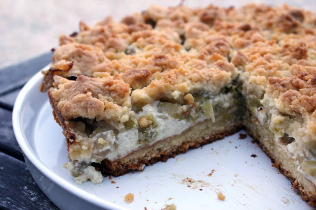 angeschnittener Rhabarberkuchen mit Schmandcreme und Streuseln