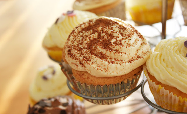 Tiramisu-Cupcakes zusammen mit anderen Cupcakes auf einem Cupcakeständer