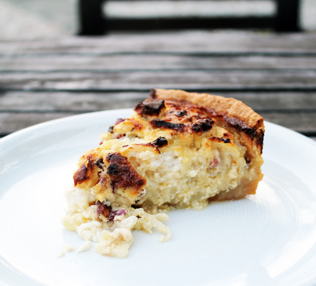 ein Stück frisch gebackener Zwieblkuchen mit Speck und Feta, deftig und würzig