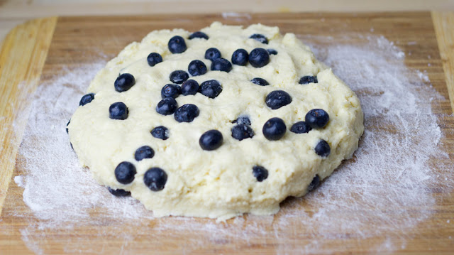 Teig für Scones mit Blaubeeren und Sahne wird in Form gebracht