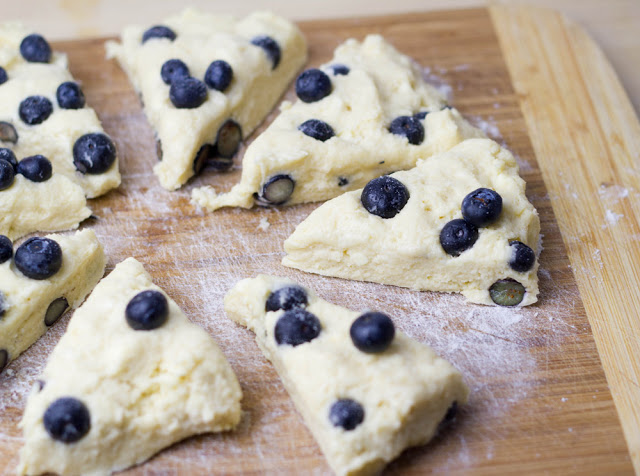 Der Teig für die Scones mit Blaubeeren und Sahne wird in Tortenstücke geteilt