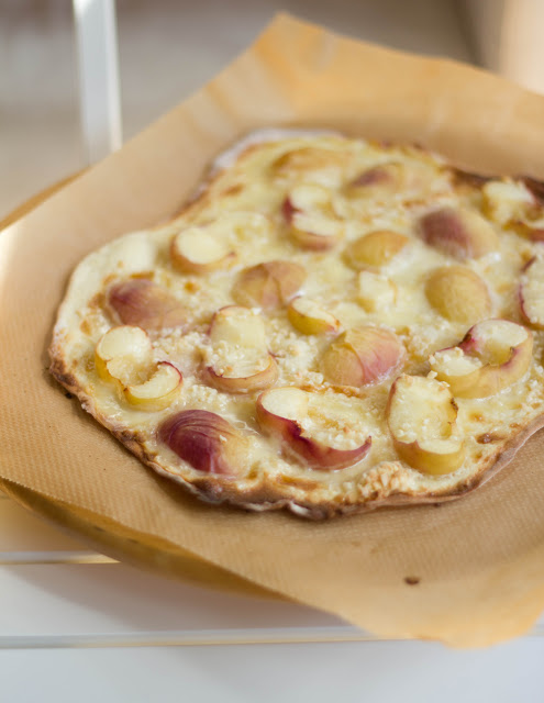 Rezept für süße Flammkuchen mit frischen Pfirsichen und Mandeln warmer, weißer Pfirsich auf frisch gebackenem, süßem Flammkuchen