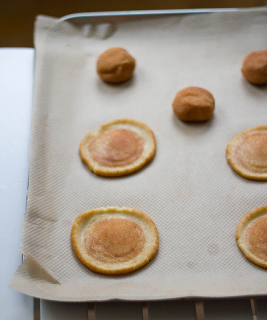 Rezept für Weihnachtsplätzchen: amerikanische Snickerdoodles mit Zimt und brauner Butter die Teigkugeln werden mit Hilfe eines Glases platt gedrückt