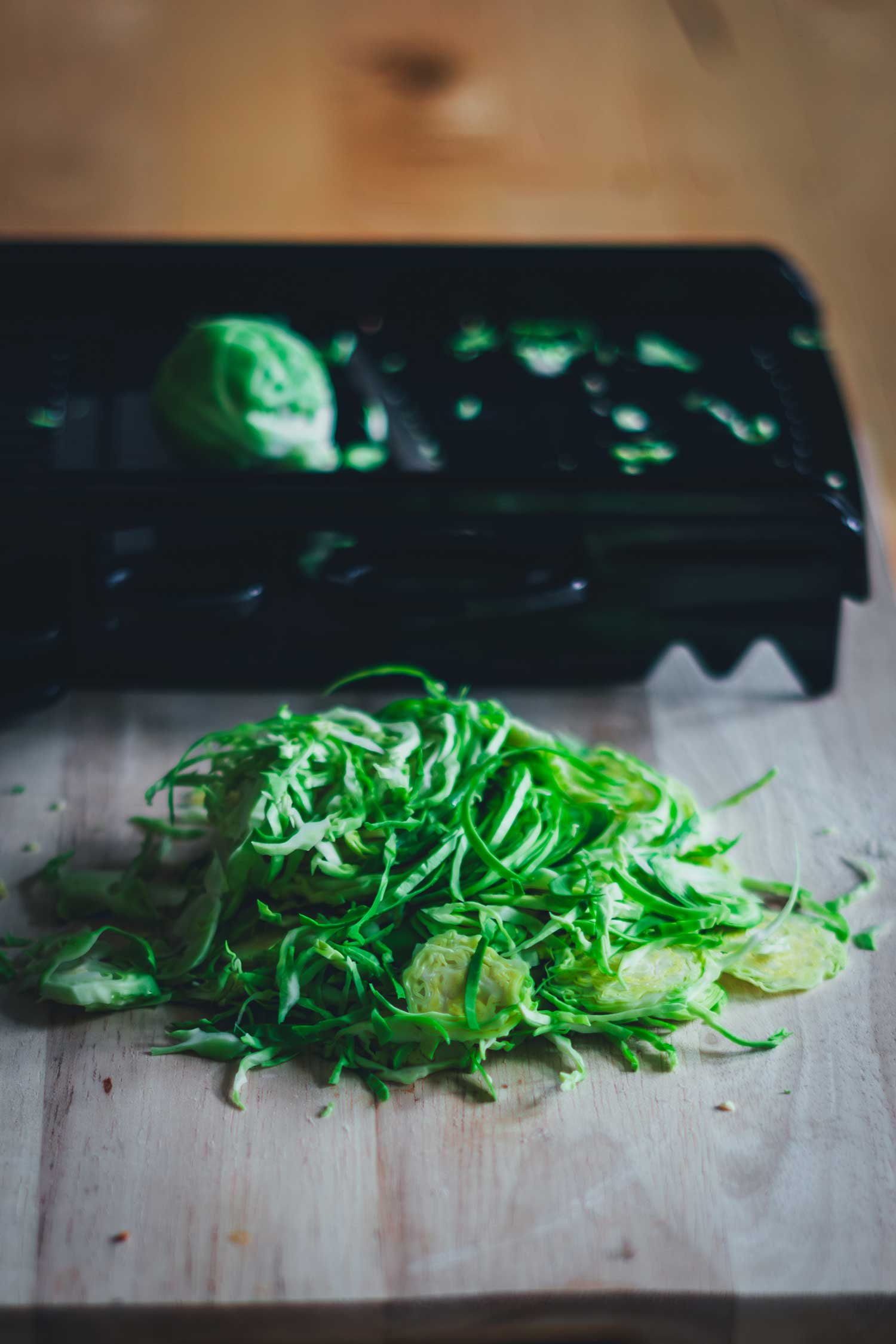 Fein gehobelter Rosenkohl auf einem Holzbrett – Basis für rohen Rosenkohlsalat