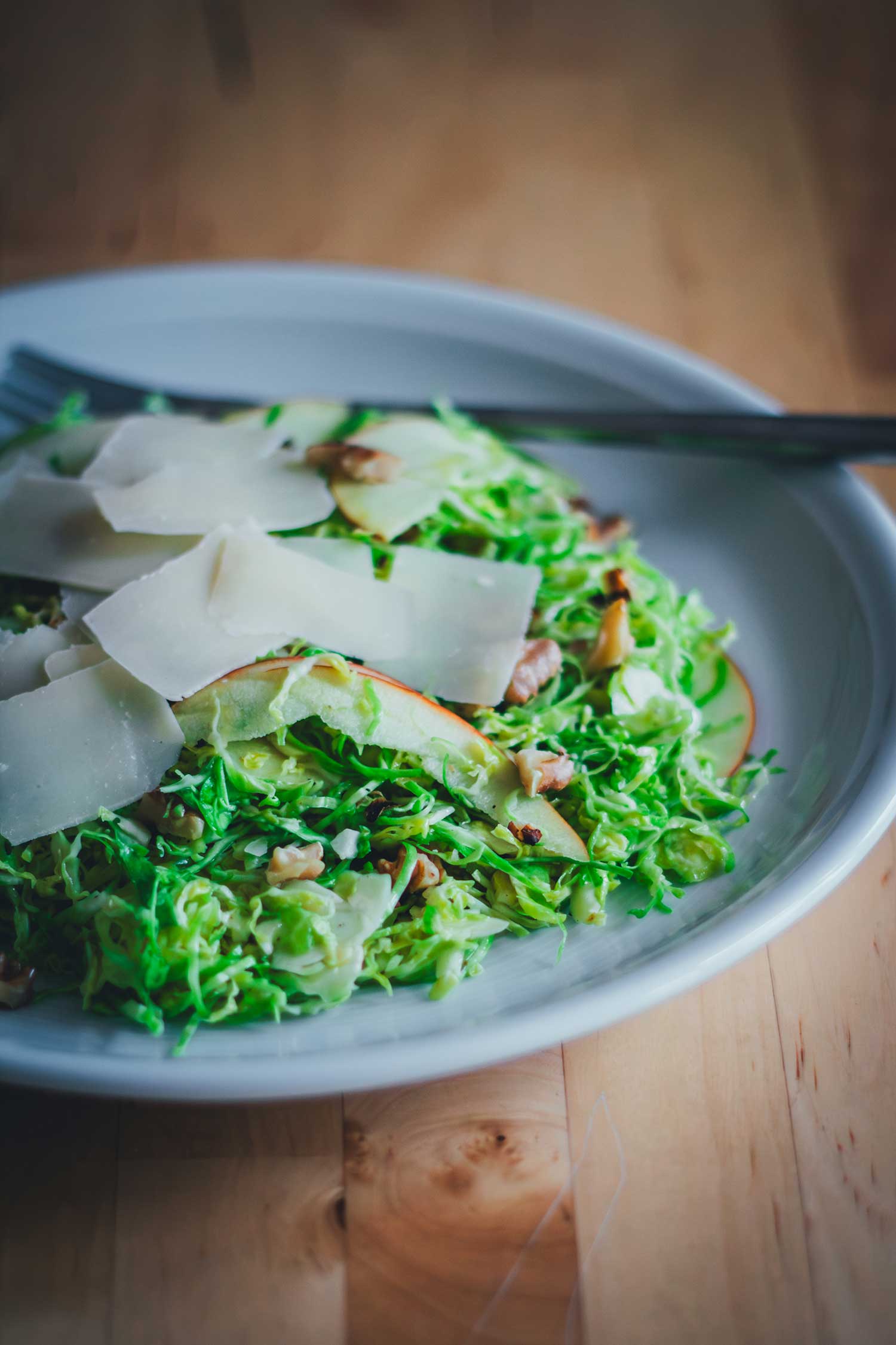 Rosenkohlsalat mit Apfel, Walnüssen und Pecorino – frischer Wintersalat auf einem Teller