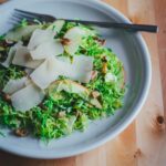 Rosenkohlsalat mit Apfel, Walnüssen und Pecorino – frischer Wintersalat auf einem Teller