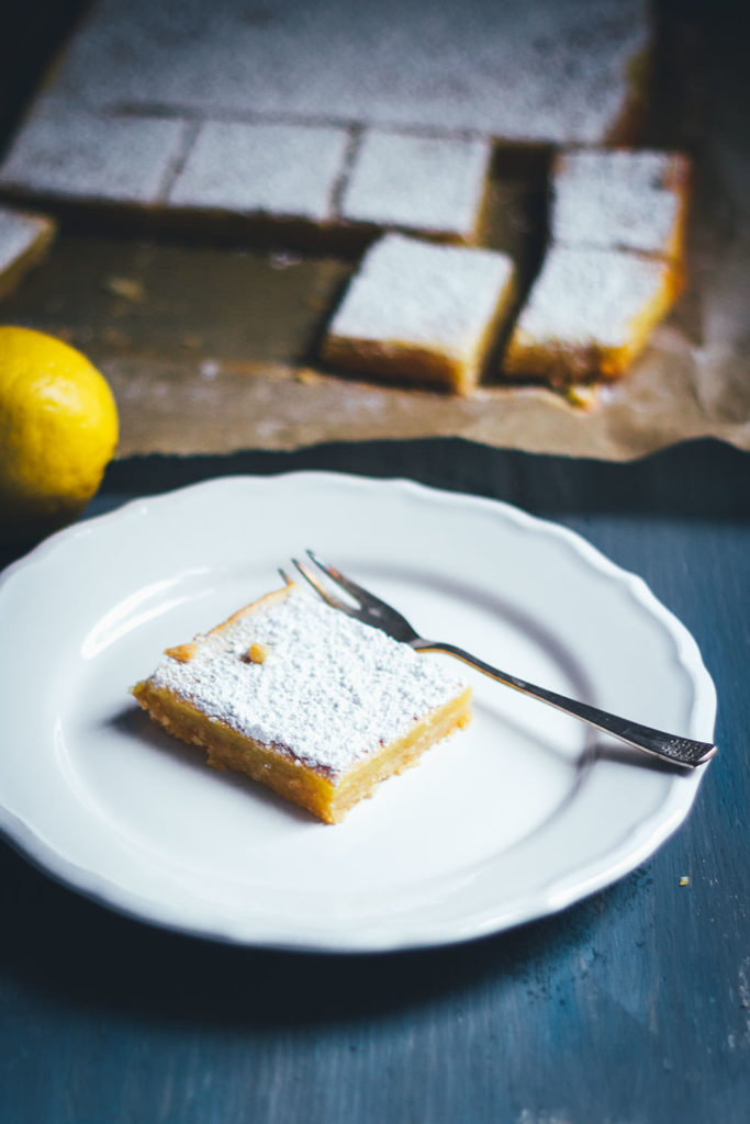 Saftige Zitronenschnitten oder auch Lemon Square Bars passen hervorragend ins Frühjahr. Ein einfacher Mürbeteigboden, dazu eine süß-säuerliche Zitronenfüllung. So lecker und einfach umzusetzen und perfekt für Ostern und fürs Frühjahr! | moeyskitchen.com