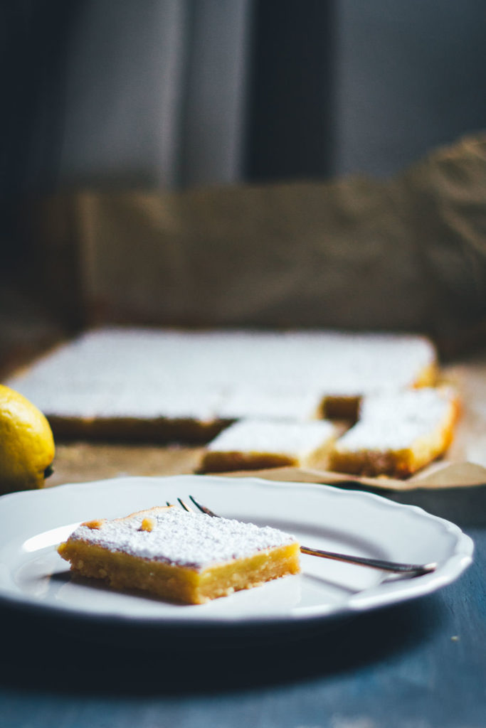 Saftige Zitronenschnitten oder auch Lemon Square Bars passen hervorragend ins Frühjahr. Ein einfacher Mürbeteigboden, dazu eine süß-säuerliche Zitronenfüllung. So lecker und einfach umzusetzen und perfekt für Ostern und fürs Frühjahr! | moeyskitchen.com