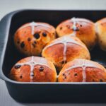 Ansicht von einer Backform, gefüllt mit fluffigen Schokobrötchen, als Hot Cross Buns mit Zuckerguss gebacken