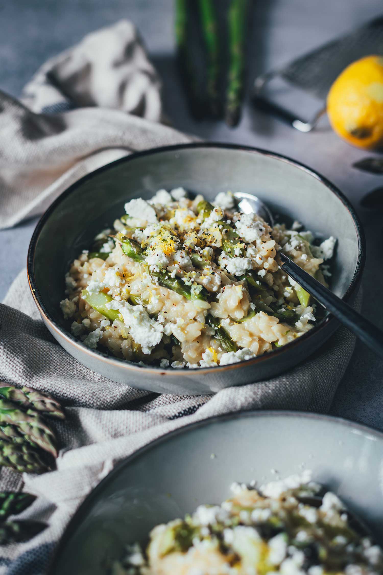 Spargel Risotto aus dem Ofen in grauer Schale, angerichtet mit Schafsmilch-Feta und frischem Zitronenabrieb