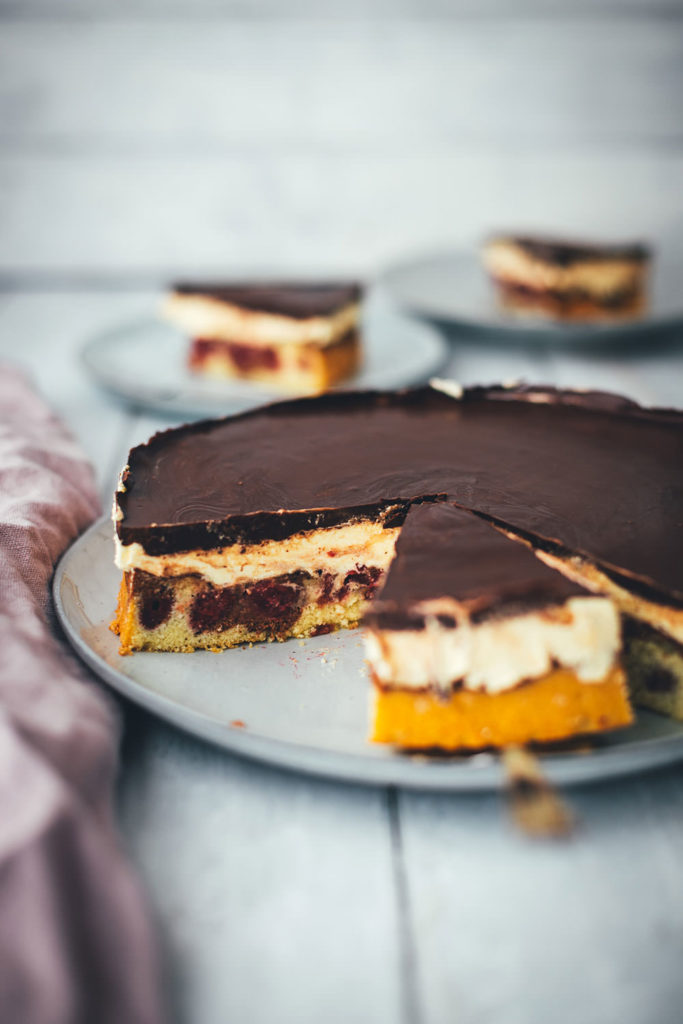 Hier gibt es das Rezept für eine leckere Donauwelle! Der Kuchenklassiker besteht aus einem hellen und dunklen Rührteig mit Schattenmorellen oder Kirschen, einer Pudding-Buttercreme und einer Schokoladen-Glasur. Der Kuchen benötigt etwas Ruhe- und Kühlzeit, ist aber super einfach zu backen! Ein absolutes Lieblingsrezept. | moeyskitchen.com