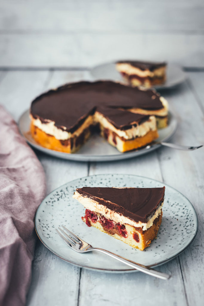 Hier gibt es das Rezept für eine leckere Donauwelle! Der Kuchenklassiker besteht aus einem hellen und dunklen Rührteig mit Schattenmorellen oder Kirschen, einer Pudding-Buttercreme und einer Schokoladen-Glasur. Der Kuchen benötigt etwas Ruhe- und Kühlzeit, ist aber super einfach zu backen! Ein absolutes Lieblingsrezept. | moeyskitchen.com