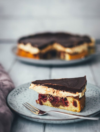 Hier gibt es das Rezept für eine leckere Donauwelle! Der Kuchenklassiker besteht aus einem hellen und dunklen Rührteig mit Schattenmorellen oder Kirschen, einer Pudding-Buttercreme und einer Schokoladen-Glasur. Der Kuchen benötigt etwas Ruhe- und Kühlzeit, ist aber super einfach zu backen! Ein absolutes Lieblingsrezept. | moeyskitchen.com