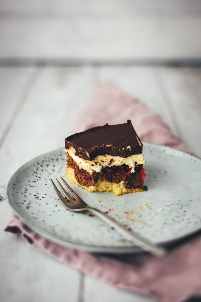 Hier gibt es das Rezept für eine leckere Donauwelle! Der Kuchenklassiker besteht aus einem hellen und dunklen Rührteig mit Schattenmorellen oder Kirschen, einer Pudding-Buttercreme und einer Schokoladen-Glasur. Der Kuchen benötigt etwas Ruhe- und Kühlzeit, ist aber super einfach zu backen! Ein absolutes Lieblingsrezept. | moeyskitchen.com