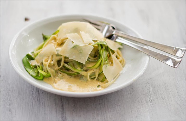 Früglingsgericht auf Teller: Pasta mit grünem Spargel in Streifen, Parmesansauce und Parmesanspänen