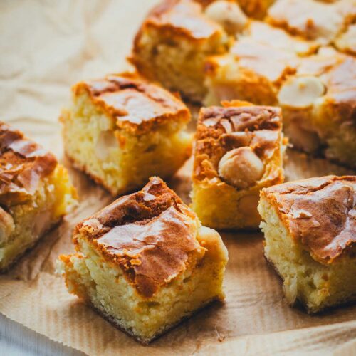 Rezept für saftige Blondies mit weißer Schokolade und gesalzenen Macadamias. Das sind quasi goldbraune Brownies ohne dunkle Schokolade, mit karamelligem Geschmack. Schnell gemacht aus nur wenigen Zutaten. Ein echtes Standardrezept! | moeyskitchen.com