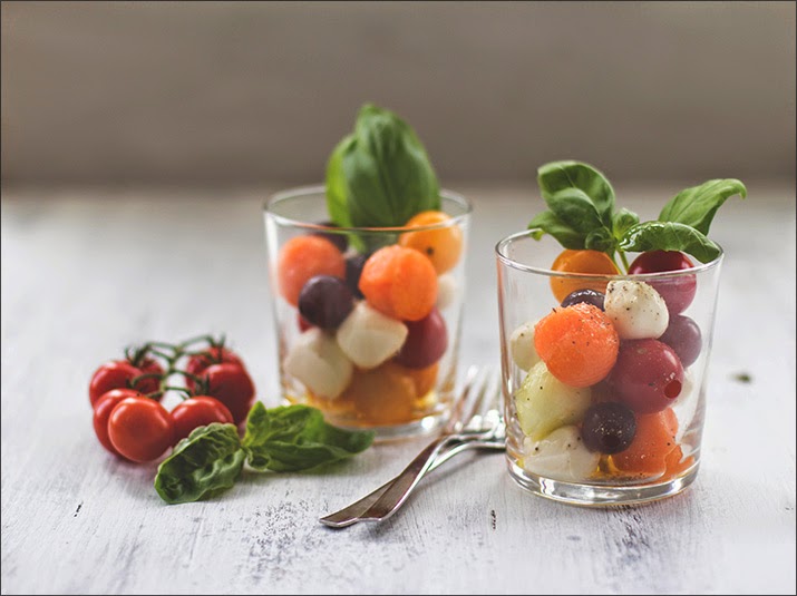 Kugelsalat aus Tomaten, Mozzarella, Melone, Gurke und Trauben Obst und Gemüse mit Mozzarellakugeln als sommerfrischer Salat im Glas