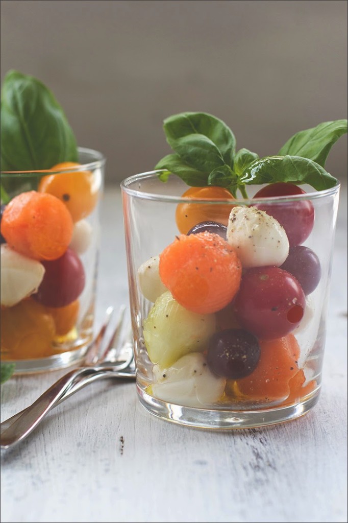 Kugelsalat aus Tomaten, Mozzarella, Melone, Gurke und Trauben Obst und Gemüse mit Mozzarellakugeln als sommerfrischer Salat im Glas