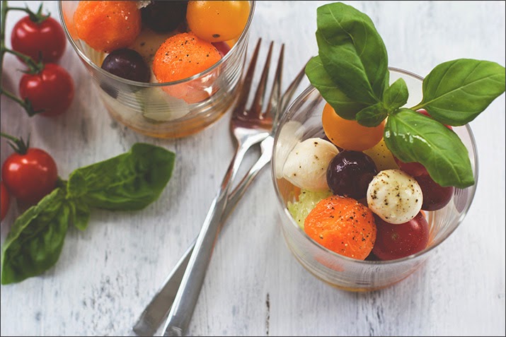 Kugelsalat aus Tomaten, Mozzarella, Melone, Gurke und Trauben Obst und Gemüse in Kugelform im Glas geschichtet