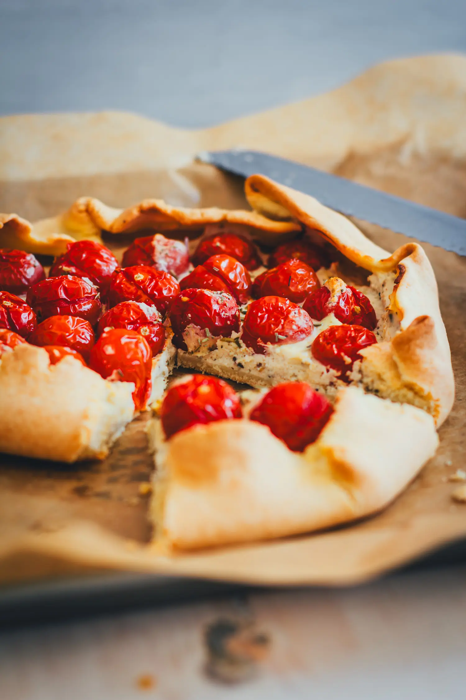 Anschnitt der Tomaten-Galette mit der Schicht aus gestockter Ricottacreme über dem gebackenen Boden