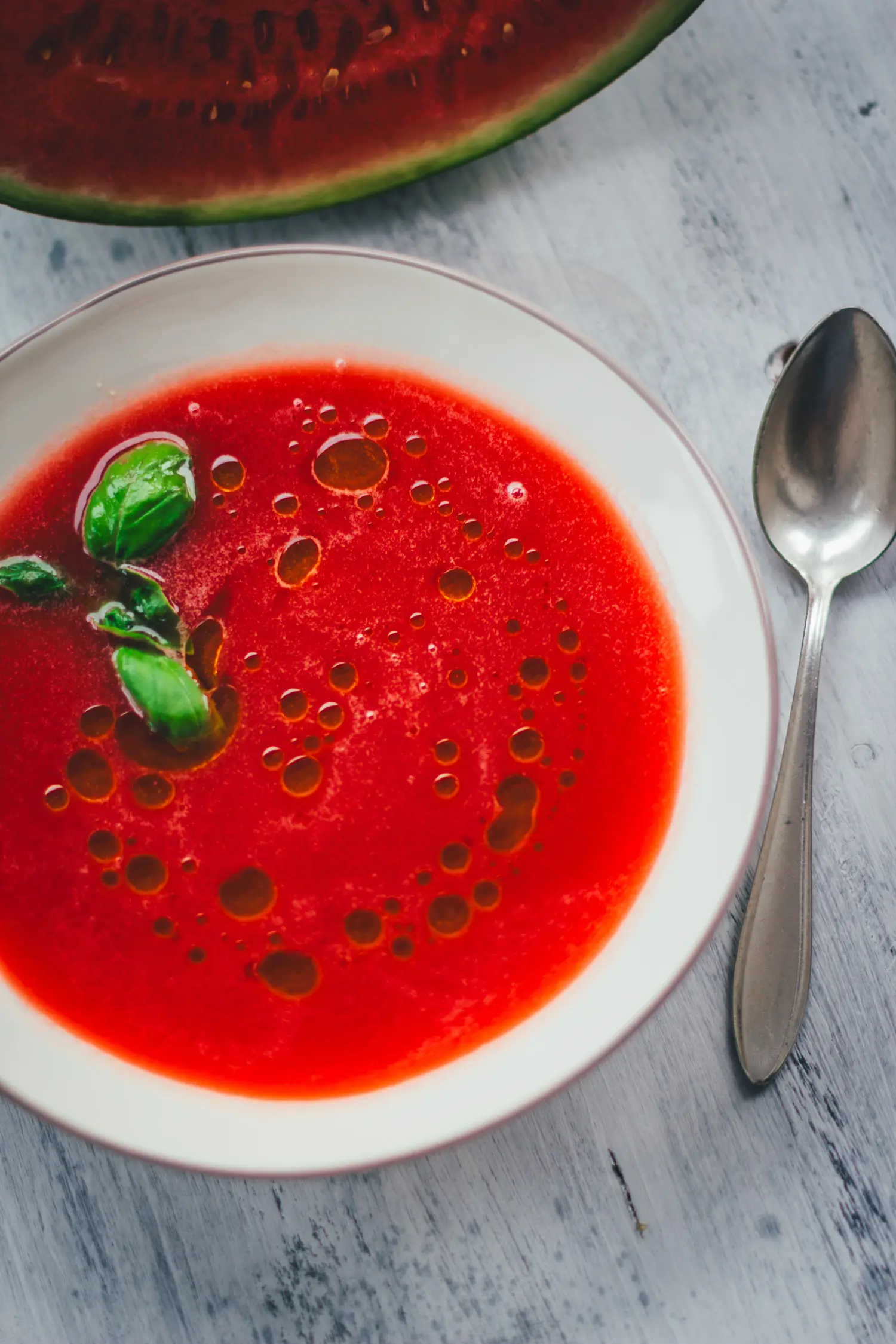 Seidig pürierte Wassermelonen-Gazpacho mit frischem Basilikum und Olivenöl von oben