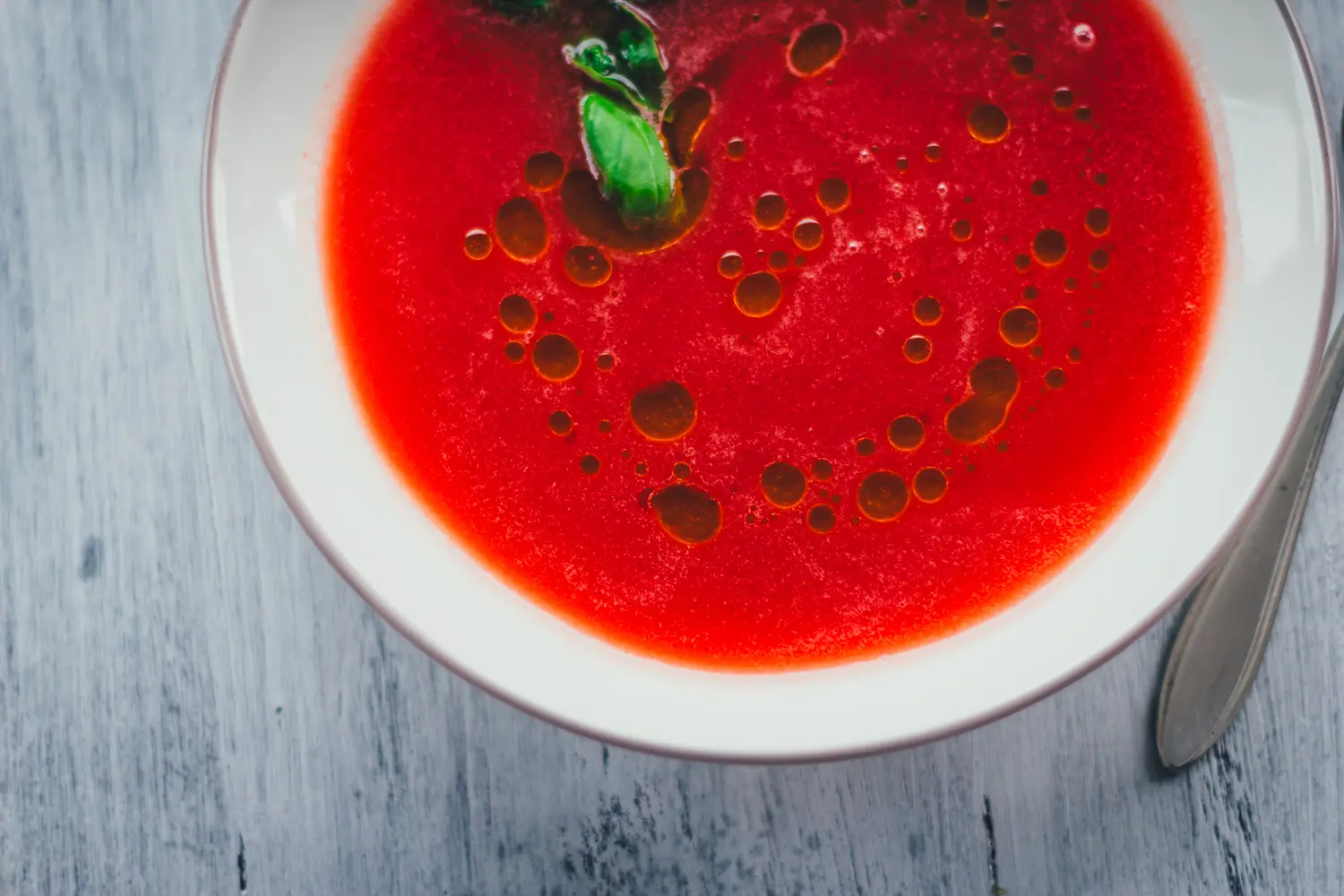 Nahaufnahme der seidigen Wassermelonen-Gazpacho mit Olivenöl und Basilikum