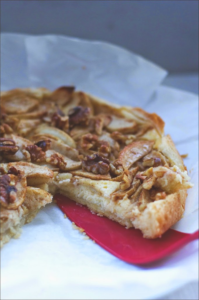 Schnelles Rezept Apfelkuchen mit Frischkäse-Guss und Walnüssen Angeschnittener Apfelkuchen auf einer Servierplatte