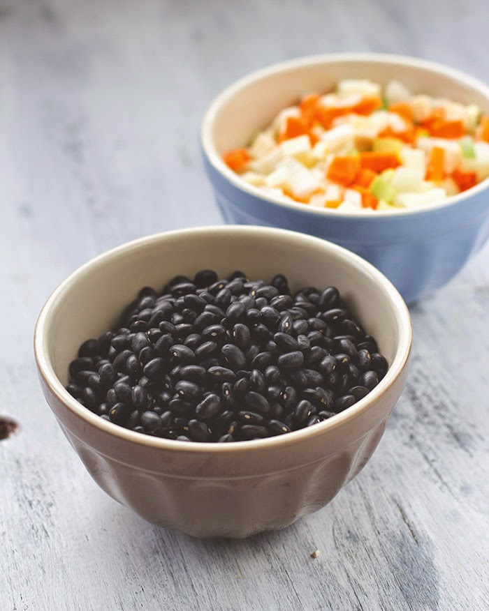 Rezept für schwarze Bohnensuppe mit Saurer Sahne, Guacamole, Limette und Koriander getrocknete schwarze Bohnen und fein gewürfeltes Suppengrün als Grundlage für die Bohnensuppe