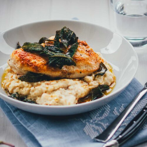 Rezept für gebratene Hähnchenbrust mit Bohnen-Ziegenfrischkäse-Püree und Salbeibutter. Zufällig low-carb und sooo lecker! Klingt aufwendig, steht aber in nur 30 Minuten auf dem Tisch und macht richtig was her! | moeyskitchen.com