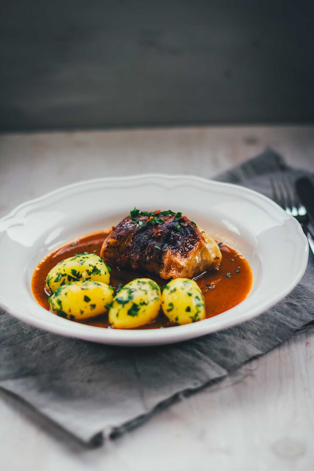 Klassische Kohlrouladen mit Fleischfüllung in Sauce und Petersilienkartoffeln