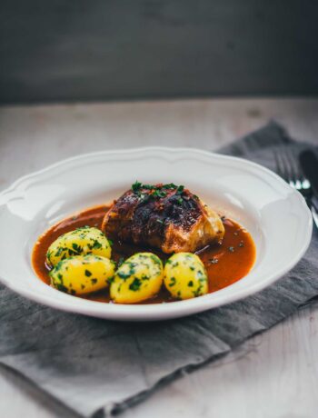 Klassische Kohlrouladen mit Fleischfüllung in Sauce und Petersilienkartoffeln