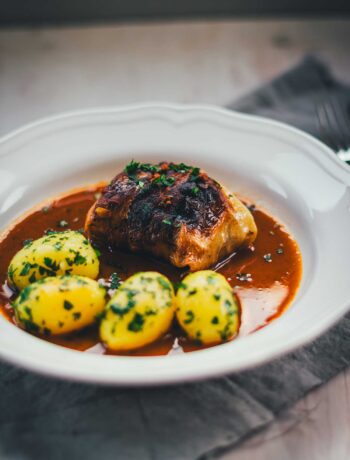 Klassische Kohlrouladen mit Fleischfüllung in Sauce und Petersilienkartoffeln