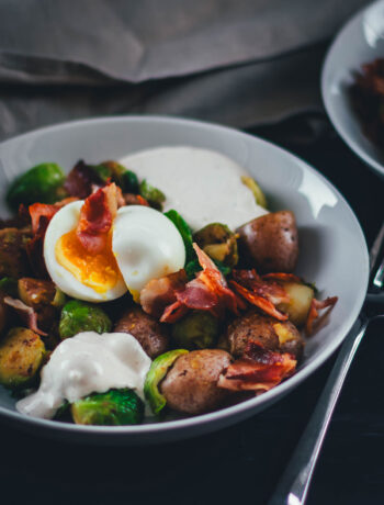 Hier teile ich mein Rezept für eine deftige Rosenkohl-Kartoffel-Pfanne. Serviert mit wachsweichem Ei, knusprigem Bacon und würzigem Knoblauch-Schmand. Perfekt für die schnelle Feierabendküche in Herbst und Winter! | moeyskitchen.com