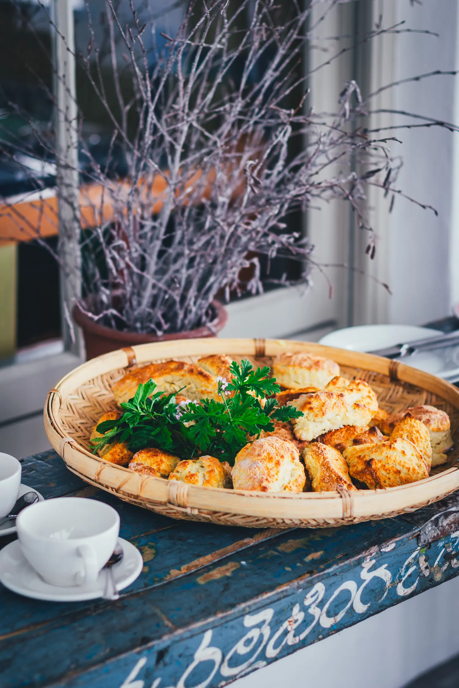 Frisch gebackene irische Scones in einem Weidenkorb, mit Kräutern und Zucker bestreut