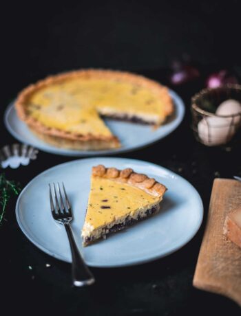 Stück Zwiebelquiche auf Teller im Fokus, im Hintergrund unscharf die restliche Quiche auf Teller sichtbar | moeyskitchen.com