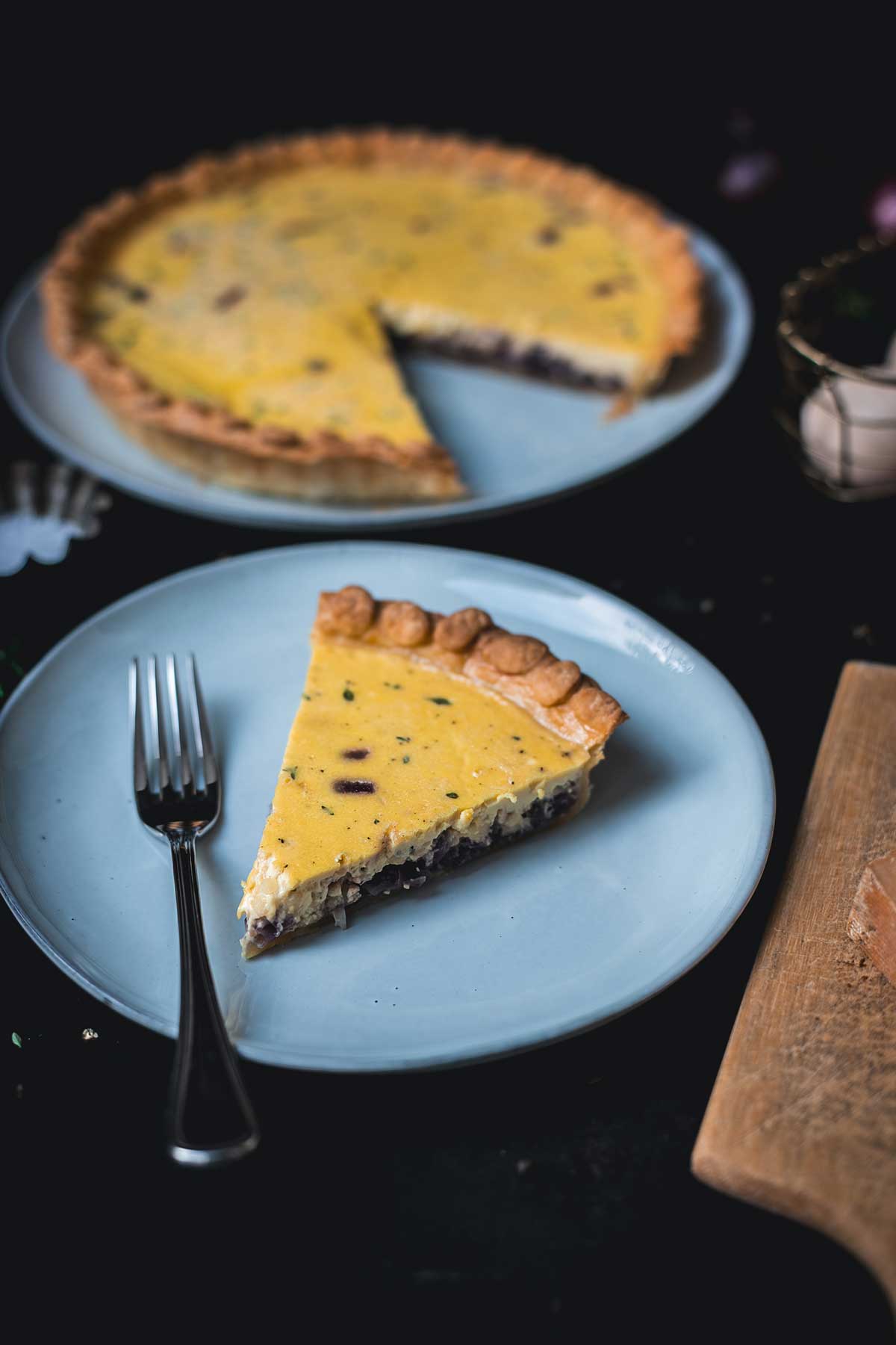 Zwiebelquiche bei 45 Grad, Nahaufnahme eines Stücks auf Teller im Vordergrund, cremige Füllung mit karamellisierten Zwiebeln sichtbar | moeyskitchen.com