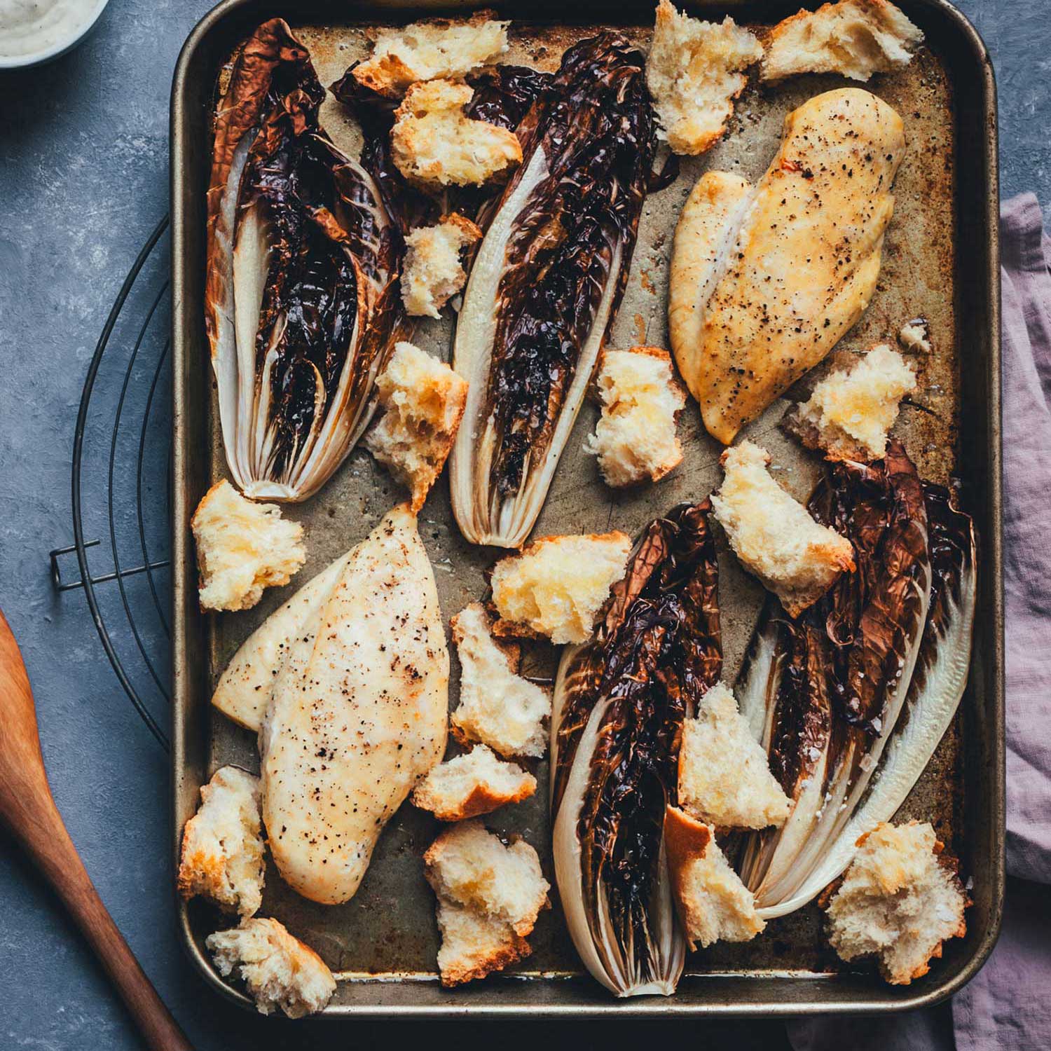 Frisch gerösteter Radicchio vom Blech mit Hähnchen und knusprigen Baguette-Croutons direkt nach dem Backen.