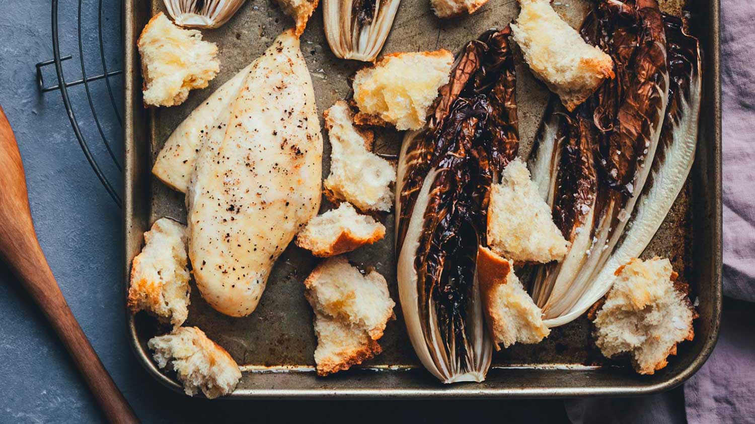 Topshot vom Blech mit frisch geröstetem Radicchio, Hähnchen und Croutons, die gleich als Caesar Chicken Salad serviert werden.