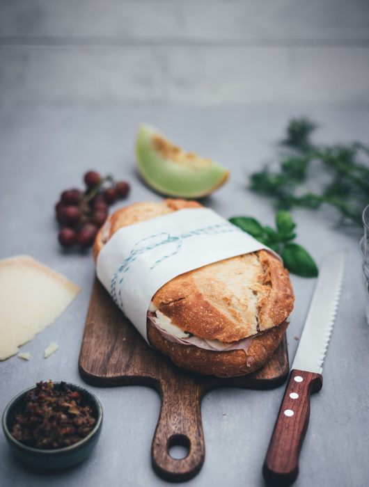 Rezept für italienisches Sandwich "Muffuletta Style" zum Picknick wie in Italien | gepresstes Weißbrot mit einer Füllung aus Oliven-Tapenade, Prosciutto Cotto, Salame Milanese, Provolone, Mozzarella und gegrillter Paprika | moeyskitchen.com #sandwich #panini #picknick #italienisch #muffuletta #brot #worlpicknickday #belegtesbrot #schnittchen #rezepte #foodblogger