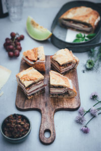 Rezept für italienisches Sandwich "Muffuletta Style" zum Picknick wie in Italien | gepresstes Weißbrot mit einer Füllung aus Oliven-Tapenade, Prosciutto Cotto, Salame Milanese, Provolone, Mozzarella und gegrillter Paprika | moeyskitchen.com #sandwich #panini #picknick #italienisch #muffuletta #brot #worldpicknickday #belegtesbrot #schnittchen #rezepte #foodblogger