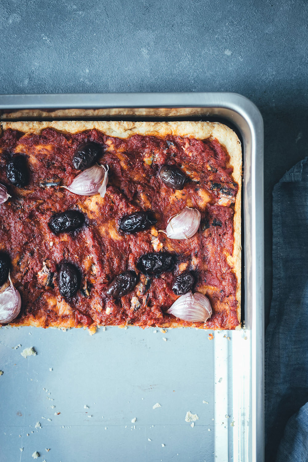 Rezept für Sardenaira: ligurische Focaccia – Pizza mal anders | knuspriger Hefeteig mit reichlich Olivenöl, Tomatensauce, Sardinen, Oliven und Knoblauche | moeyskitchen.com #sardenaira #focaccia #pizza #italienisch #italienischeküche #kochen #rezepte #foodblogger #backen #hefeteig