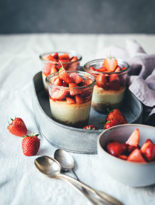 Rezept für kleine Erdbeer-Cheesecakes im Glas | individueller Cheesecake im Glas gebacken und mit frischen Erdbeeren serviert | moeyskitchen.com #cheesecake #erdbeeren #rezepte #foodblogger #käsekuchen #strawberrycheesecake #kuchen #kuchenbacken #beeren