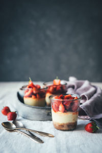 Rezept für kleine Erdbeer-Cheesecakes im Glas | individueller Cheesecake im Glas gebacken und mit frischen Erdbeeren serviert | moeyskitchen.com #cheesecake #erdbeeren #rezepte #foodblogger #käsekuchen #strawberrycheesecake #kuchen #kuchenbacken #beeren