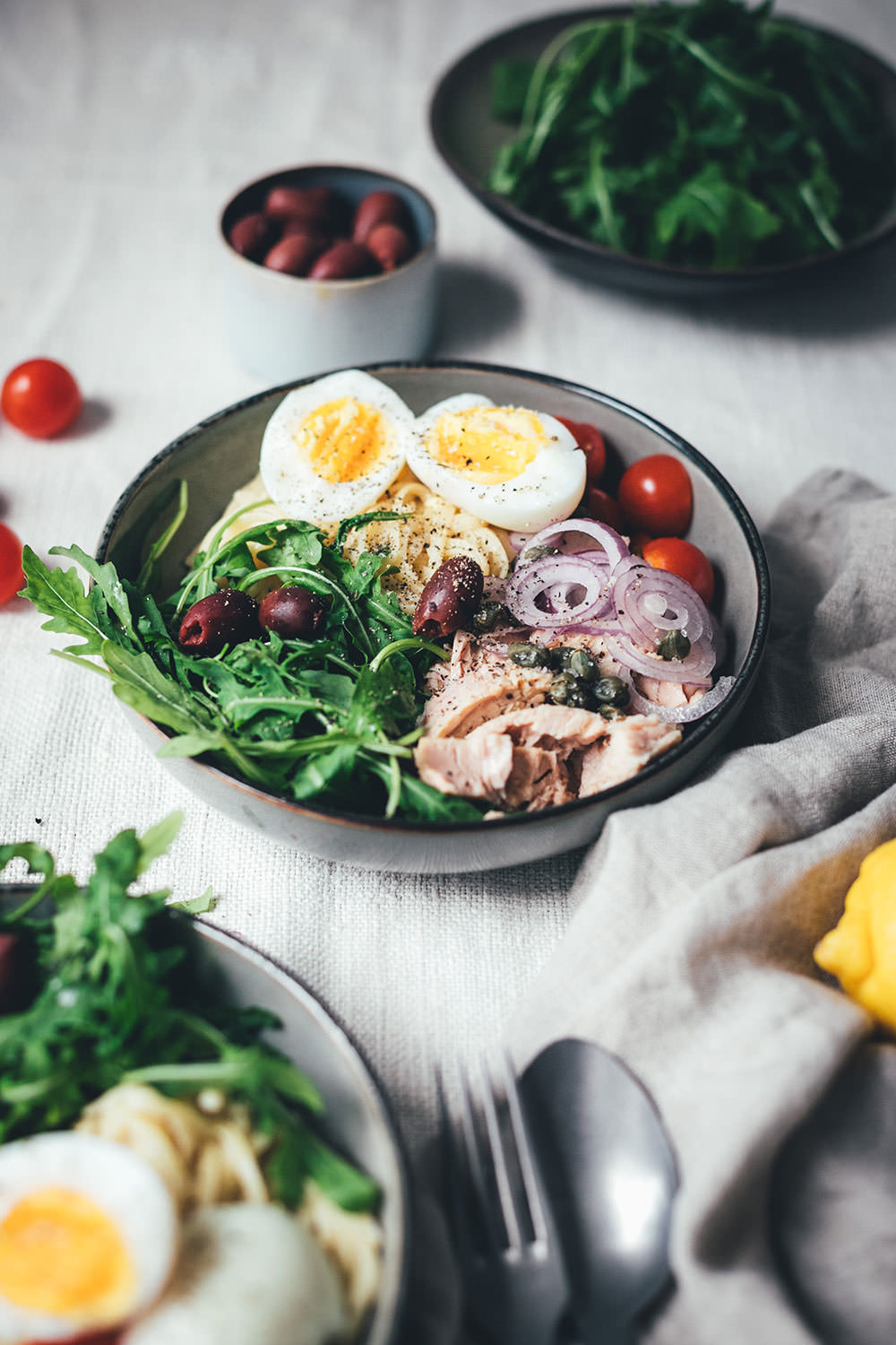 Rezept für Pasta Niçoise – in Anlehnung an den französischen Salat-Klassiker Salade Niçoise | Linguine oder Spaghetti mit Zitronen-Sauce, Rucola, Tomaten, Oliven, Zwiebeln, Kapern und wachsweichem Ei | blitzschnell auf dem Tisch | moeyskitchen.com #pasta #pastanicoise #nicoise #saladenicoise #sommerpasta #nudeln #hauptgericht #foodblog #foodblogger #rezept #kochen #schnelleküche #einfacherezepte