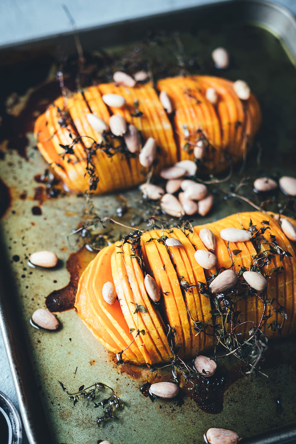 Rezept für Hasselback Kürbis | Butternusskürbis wird mit Thymian, Olivenöl, Honig, Essig und Mandeln im Ofen weich gegart | moeyskitchen.com #hasselback #hasselbackkürbis #kürbis #pumpkinboom #pumpkin #butternut #butternuss #butternutkürbis #ofen #vegetarisch #rezept #foodblog