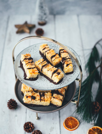 Eine tolle Abwechslung auf dem Plätzchenteller sind diese saftigen Kokos-Riegel mit Schokolade! Basis ist ein knuspriger Mürbeteig, getoppt mit einem weichen Belag aus Kokosflocken und gezuckerter Kondensmilch. Neben den ganzen Keks-Klassikern zu Weihnachten ist das eine tolle und leckere Alternative, die ich noch mit Schokolade verziere. Die Riegel erinnern von der Art her etwas an Nussecken und schmecken dezent und lecker nach Kokos. | moeyskitchen.com