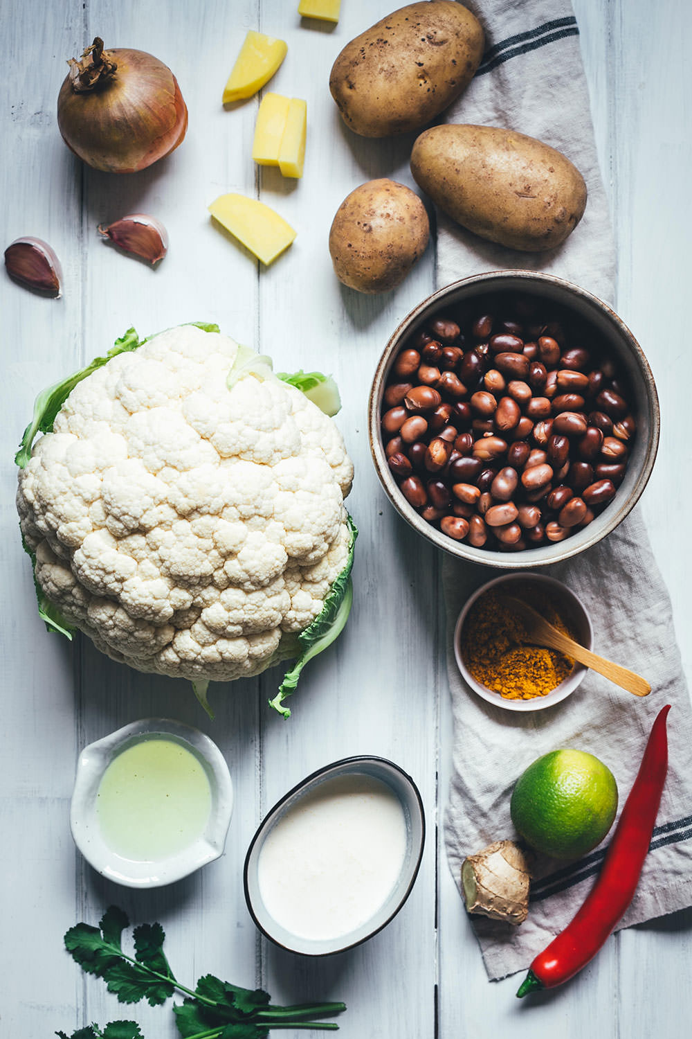 Rezept für ein würziges Blumenkohl-Kartoffel-Curry mit Ackerbohnen. Heimischer Gemüseeintopf, der an indisches Aloo Gobi bzw. Aloo Gobhi erinnert. Ackerbohnen als regionale Körnerleguminosen sind eine tolle Proteinquelle und außerdem ballaststoffreich. Und eine tolle heimische Alternative zu Kichererbsen und anderen Hülsenfrüchten. Perfekt für vegetarische und gesunde Gerichte. Madras Curry, Ingwer und Knoblauch sorgen für Würze, Chili außerdem für etwas Schärfe. Hier gibt es das einfache und unkomplizierte Rezept zum Nachkochen! | moeyskitchen.com