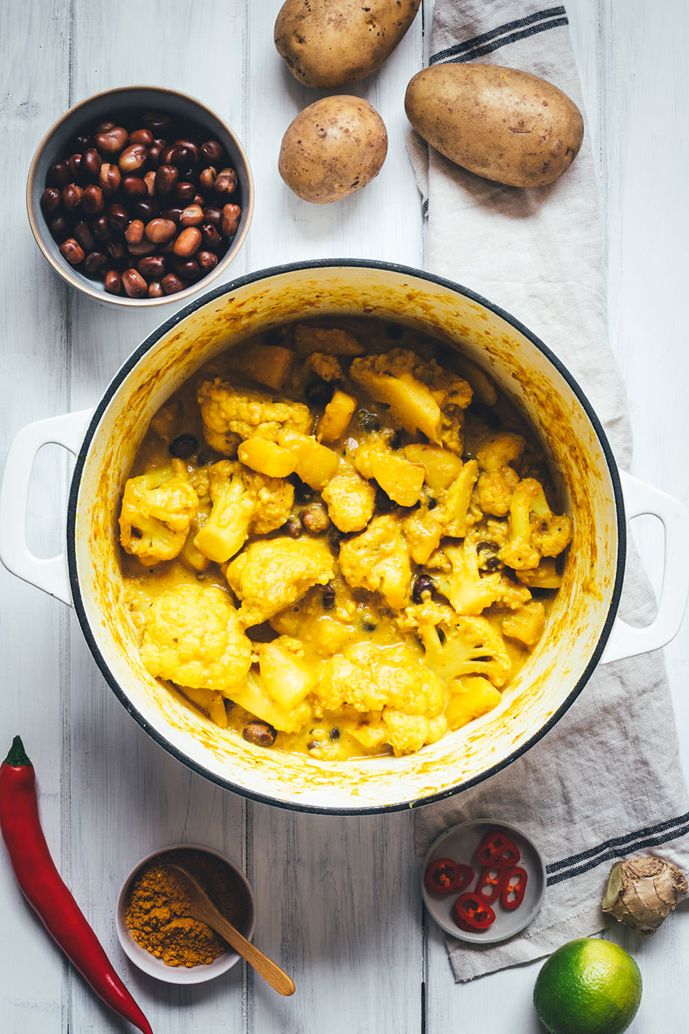 Rezept für ein würziges Blumenkohl-Kartoffel-Curry mit Ackerbohnen. Heimischer Gemüseeintopf, der an indisches Aloo Gobi bzw. Aloo Gobhi erinnert. Ackerbohnen als regionale Körnerleguminosen sind eine tolle Proteinquelle und außerdem ballaststoffreich. Und eine tolle heimische Alternative zu Kichererbsen und anderen Hülsenfrüchten. Perfekt für vegetarische und gesunde Gerichte. Madras Curry, Ingwer und Knoblauch sorgen für Würze, Chili außerdem für etwas Schärfe. Hier gibt es das einfache und unkomplizierte Rezept zum Nachkochen! | moeyskitchen.com